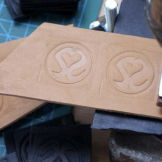 The Polisze signet embossed by hand into a piece of leather.