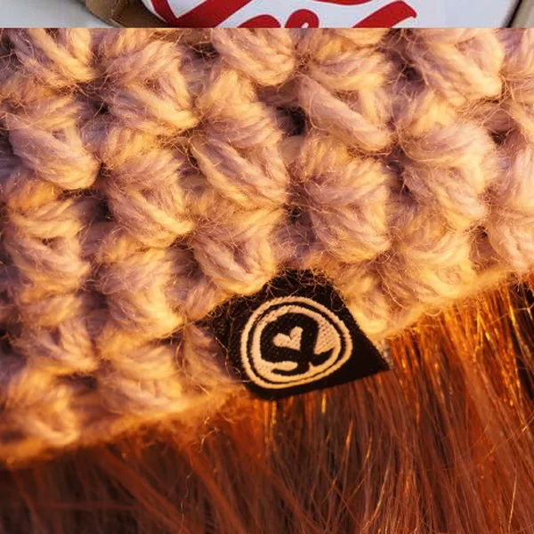Macro of a hand-crocheted beanie with a woven Polisze signet label.