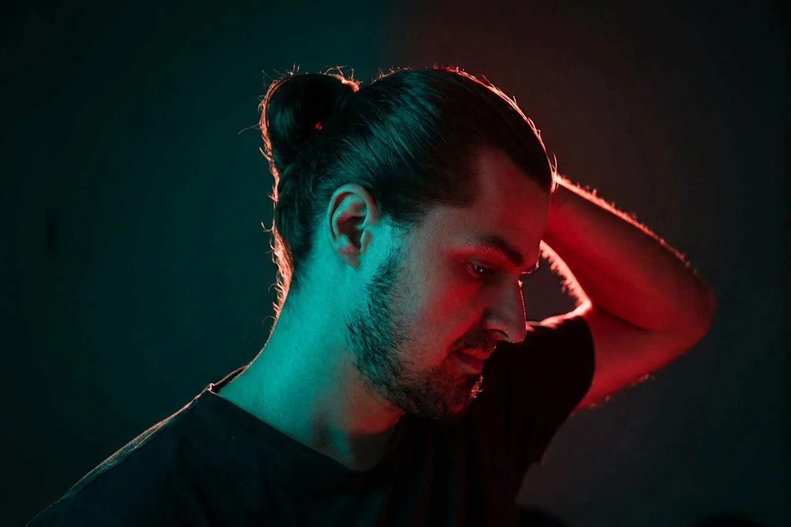 Portrait of Tom Woloszyn lit with red and teal light.